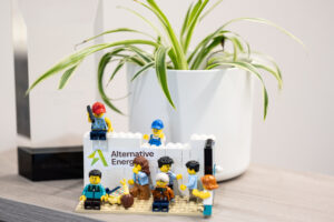 Lego scene of multiple figures working, featuring the Alternative Energy logo